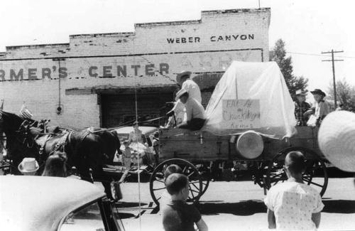 July 4th parade with a store where the post office is now located in the background
