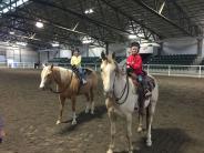 Two young girls posing on horses